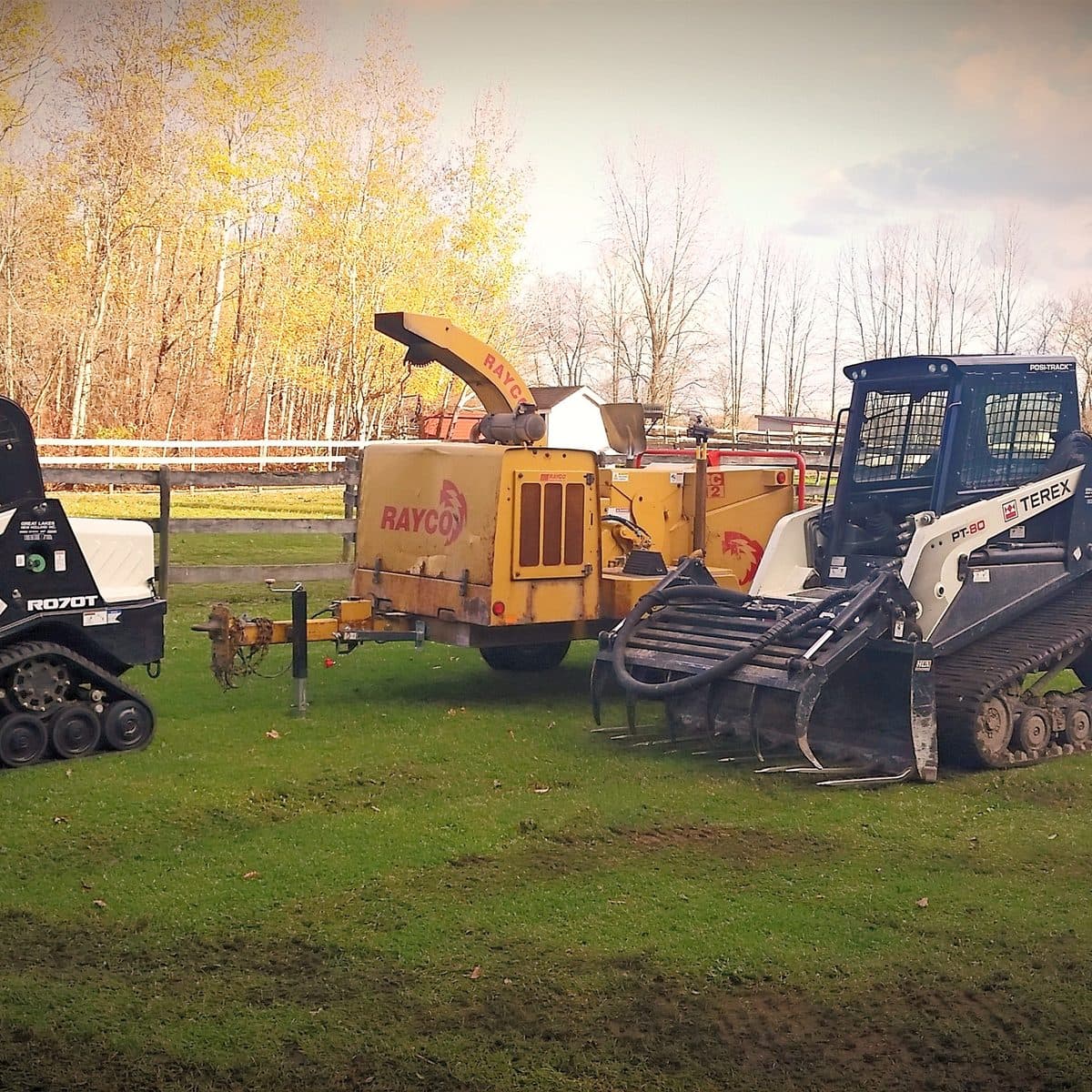 The Beaver Tree equipment fleet — tracked loaders and a Rayco wood chipper
