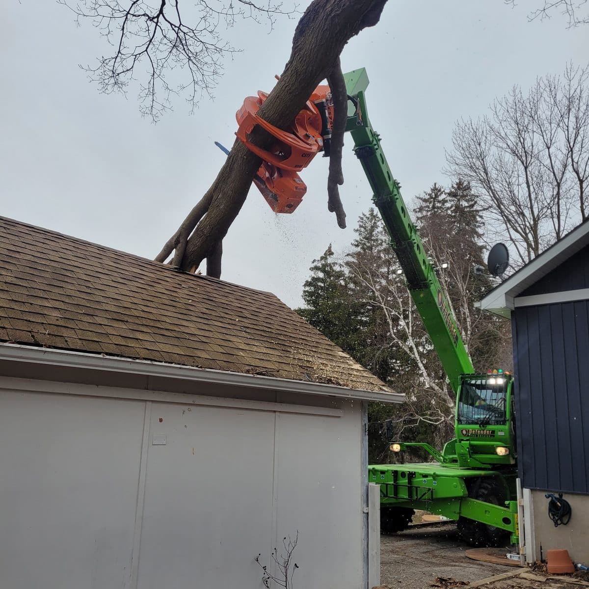 Mobile crane reaching over a rooftop during a tight-access removal